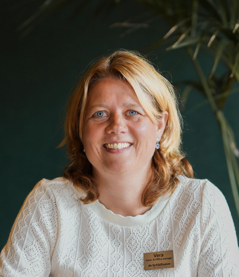 Afbeelding van onze gastvrouw Vera, glimlachend en klaar om te helpen bij het organiseren van jouw evenement op De Schildhoeve Buitengewoon