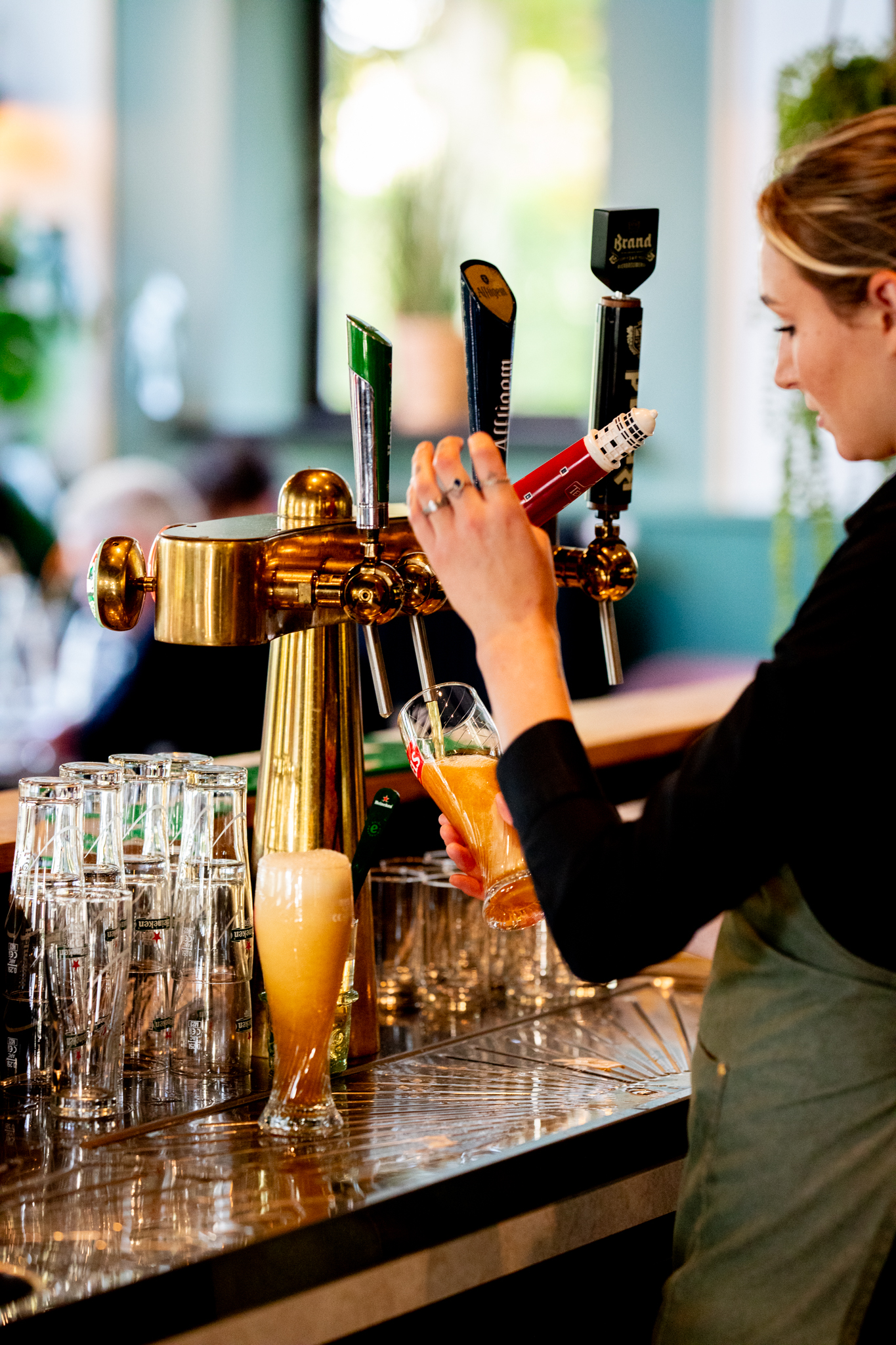 Bedieningsmedewerkster tapt vers bier van de tap bij De Schildhoeve Buitengewoon