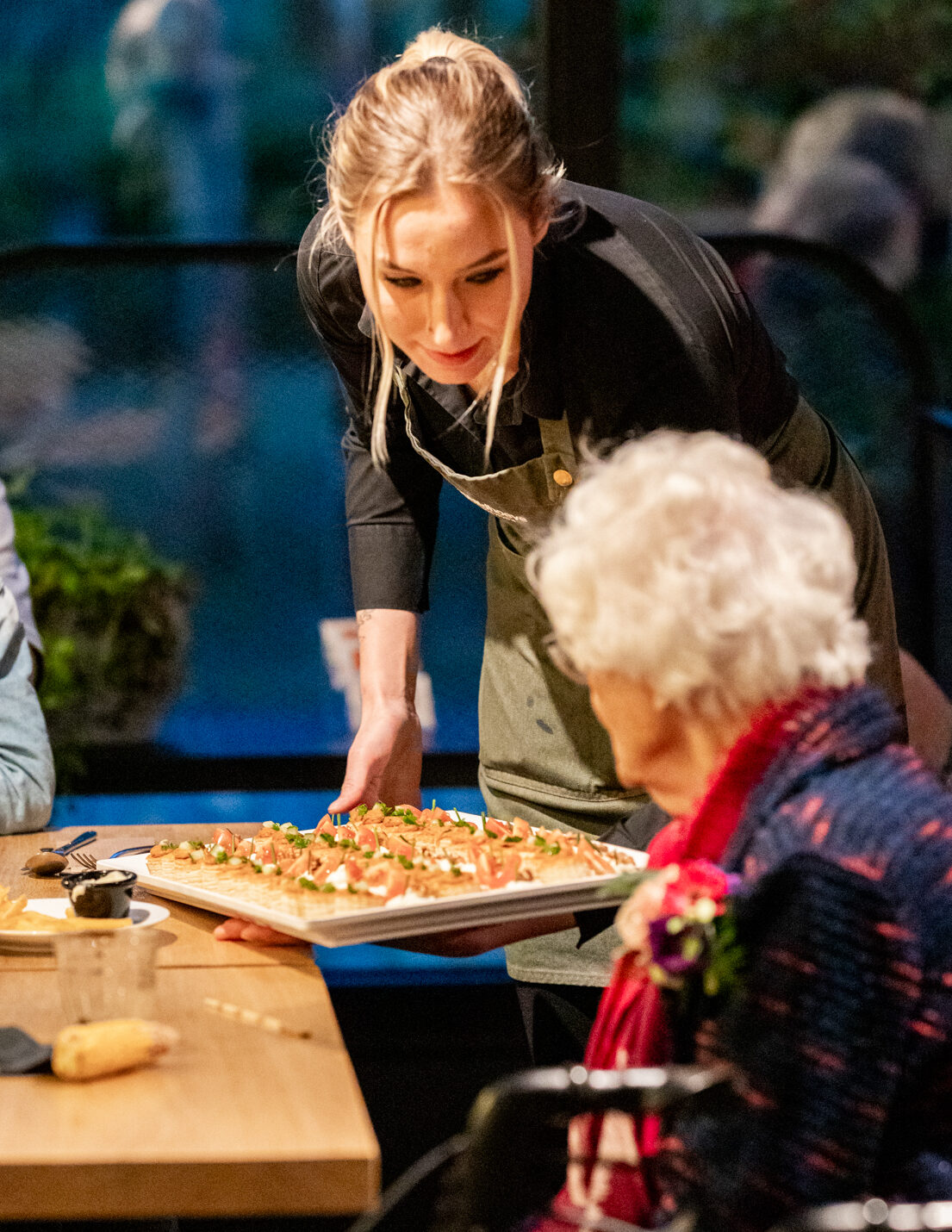 Medewerkster serveert hapjes tijdens evenement op het terras van De Schildhoeve Buitengewoon